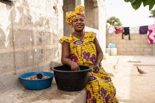 Senegalese woman preparing peanuts in her house backyard