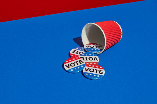 vote badges out from a red disposable cup