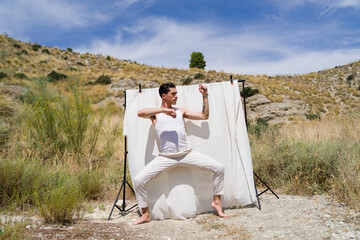 model posing in nature with white backdrop for photoshoot