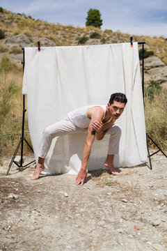 Dancer posing during photoshoot with white backdrop in nature