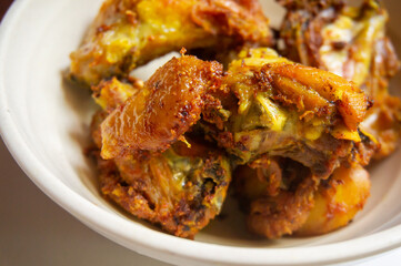 The delicious fried chicken looks very crispy served on a white bowl