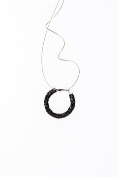 Elegant black circle earring with delicate necklace wire.
