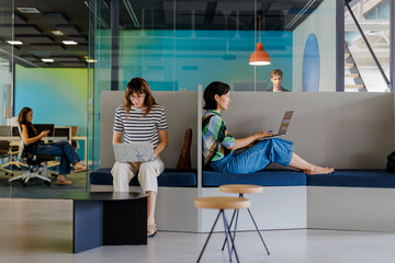 Colleagues working on laptops in a modern office space