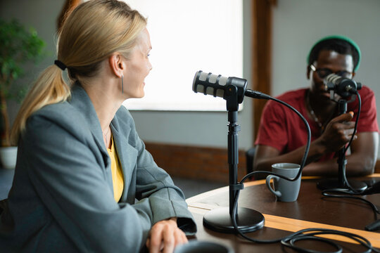 A man and a woman record a podcast