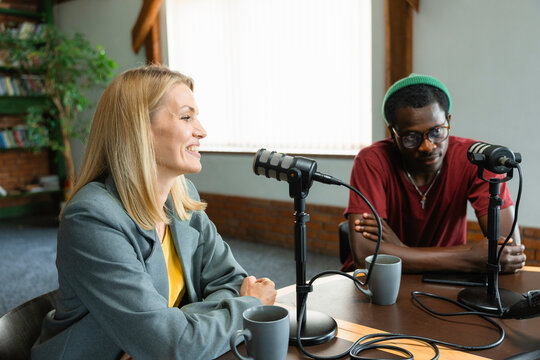 A man and a woman record a podcast