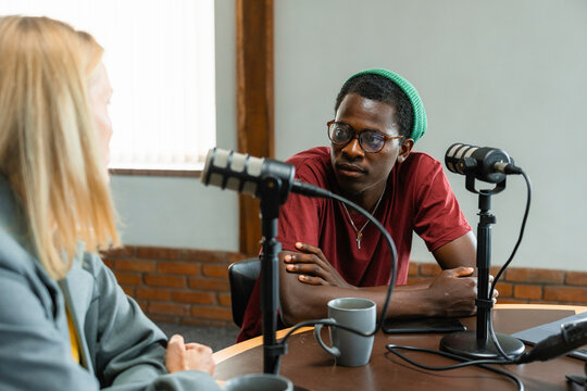 A man and a woman record a podcast
