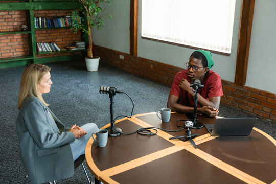 A man and a woman record a podcast