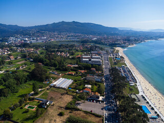 Aerial view of Playa de Samil, the main beach of Vigo in Galicia in northwest Spain. Sunny day, crystal clear blue sea. Houses, streets. Drone