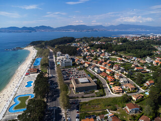Aerial view of Playa de Samil, the main beach of Vigo in Galicia in northwest Spain. Sunny day, crystal clear blue sea. Houses, streets. Drone
