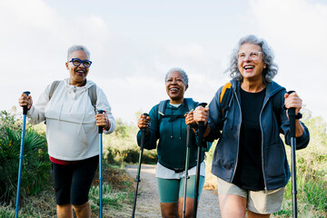 Three senior women hiking together on sunny day