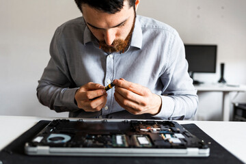 Man repairing a laptop computer