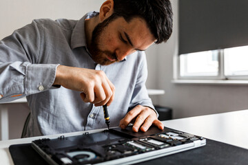 Man repairing a laptop computer