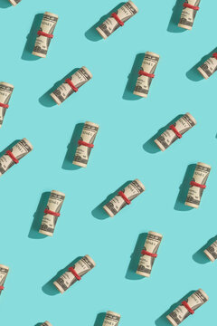 Rolled Dollar Bills Pattern on Blue Background.