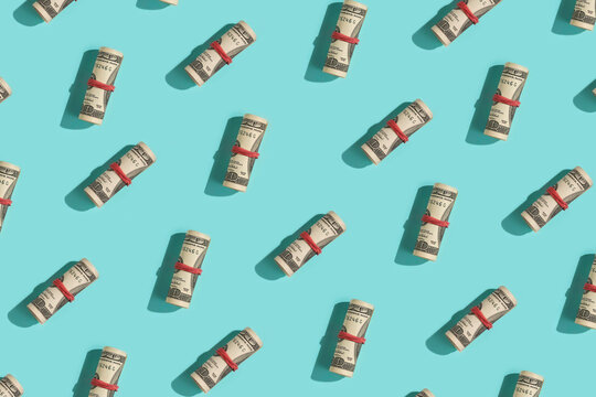 Rolled Dollar Bills Pattern on Blue Background.