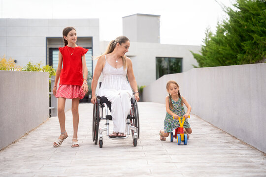 Mother and daughters enjoying a walk outside modern home