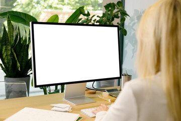 Mockup woman uses a computer with white screen at office 