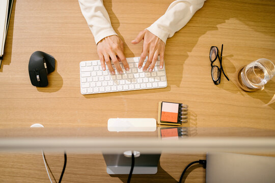 Woman Hands Typing on Keyboard at Desk Top View