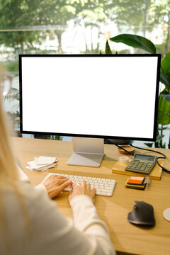 Mockup woman uses a computer with Blank Screen Desktop Workspace