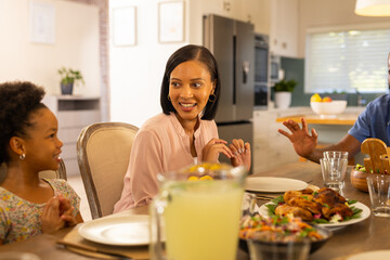 Smiling family enjoying dinner together, sharing stories and bonding at home