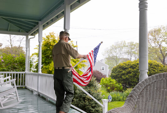 Senior military man Veteran display American Flag at House - Powered by Adobe