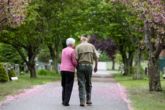 Senior  veteran walk with wife in cemetery on memorial day
