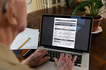 Senior citizen on computer apply Veteran Medical benefits 
