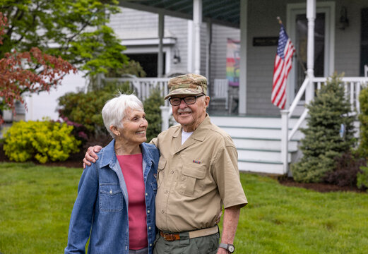 Senior Citizen Veteran Portrait front of home hug wife