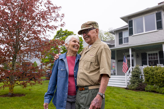 Senior Veteran Portrait front of home  hug wife 