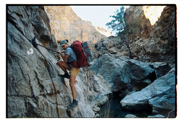 Hiker climbing down a rock face