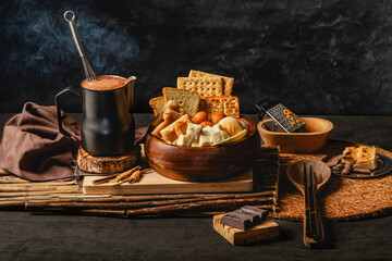 Traditional colombian baked goods migao with foamy chocolate beverage on a pot