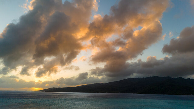 Aerial view of the beautiful tropical island Taha'a in French Polynesia, The south pacific ocean water is vibrant blue with healthy coral reefs surrounded by lush green palm trees