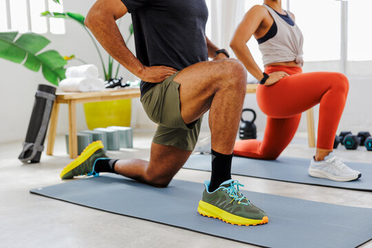 Athletes stretching legs during workout routine - Powered by Adobe