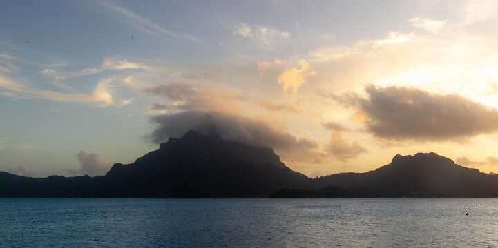 Sunrise over Bora Bora in French Polynesia. Low clouds seen above Mount Otemanu on the tropical island. 