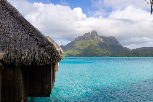 Overwater bungalow on tropical island Bora Bora. The azure lagoon is a bucket list destination for vacation travel. 