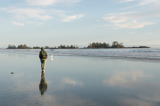 Young man enjoying a beach walk at Cox Bay, BC