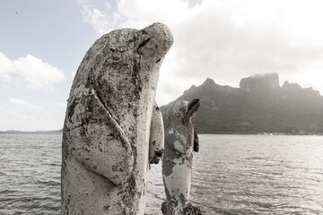 Statues of dolphins outside the water on tropical island Bora Bora.
