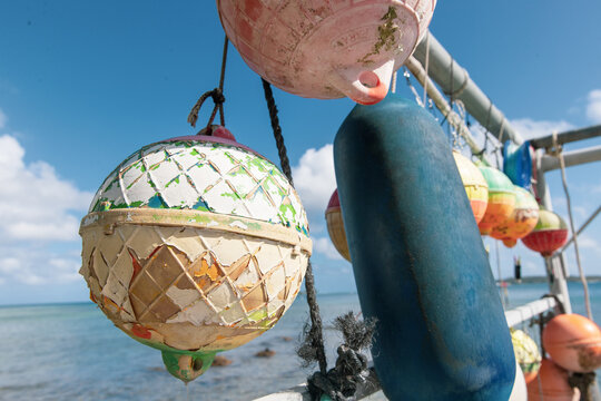 Sun faded colorful buoys for a boat hanging off a pier at tropical island Bora Bora in French Polynesia