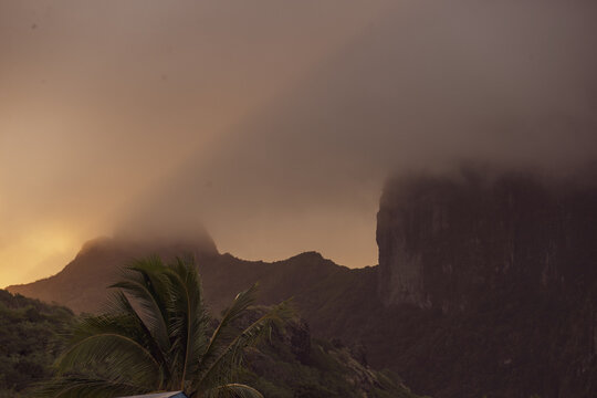 Sunrise through clouds over Mount Otemanu on the tropical island of Bora Bora