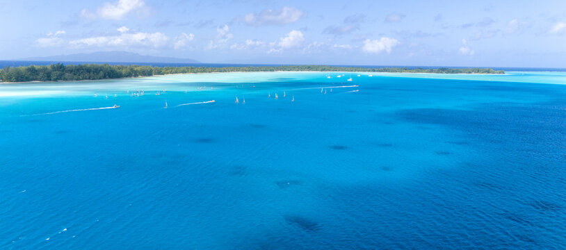 Panoramic view of vibrant azure ocean water surrounding the tropical island Bora Bora in French Polynesia. The South Pacific Sea is clear and beautiful. 