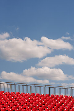 Red stadium chairs against a blue sky