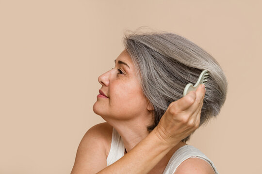 senior woman combing her gray hair