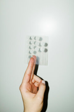 Hand holding acne pimple patch product with hard direct flashlight