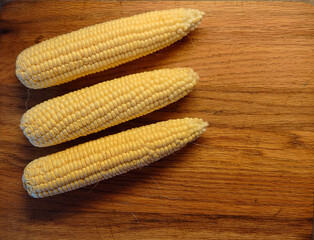 corn on the cob on red oak cutting board with space for copy