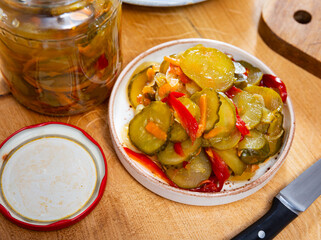 Pickled bell peppers and cucumbers in a glass jar