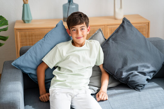 boy is sitting on a couch