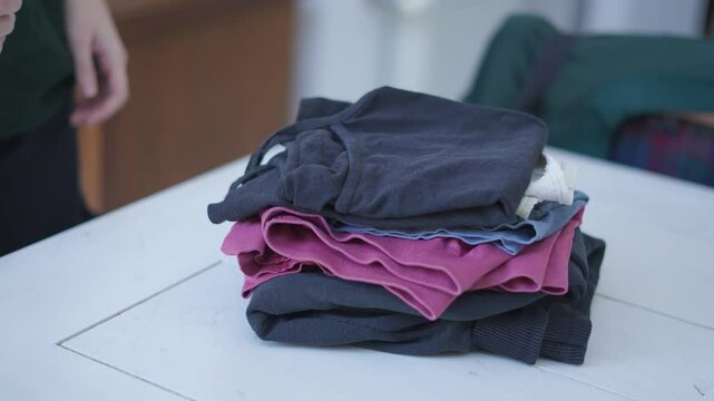 Persona doblando la ropa. Limpieza, hogar. 