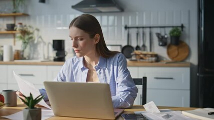 Serious woman working laptop in home office. Financial manager typing computer - Powered by Adobe
