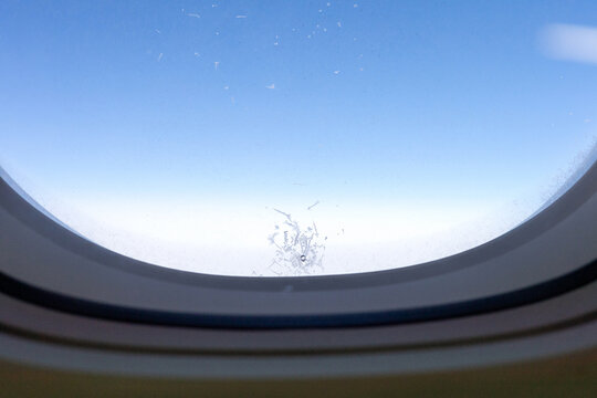 Frosty Ice Crystal Pattern on Airplane Window at High Altitude