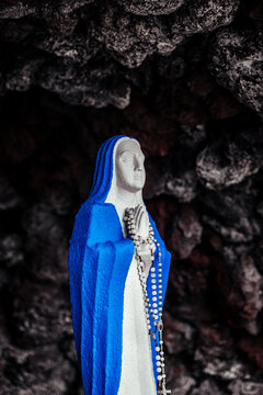 Virgin statue praying inside a cave in serene environment