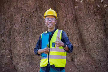 A male construction worker is inspecting and recording data in the field